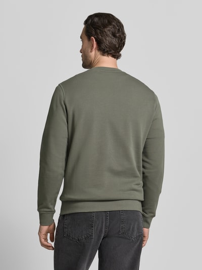 Męski model nosi Relaxed Fit Sweatshirt aus reiner Baumwolle Modell 'WESTART' od BOSS Orange, jednobarwny, label patch, długi rękaw, bawełna, widok całej sylwetki z tyłu.