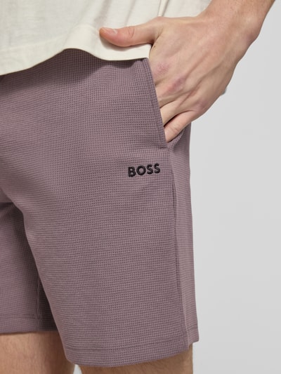 Männermodel trägt Regular Fit Sweatshorts aus katoenmix van BOSS, look: effen, wafelstructuur, tunnelkoord, zij-steekzakken, pijpboord, detailaufnahme rechterzij
