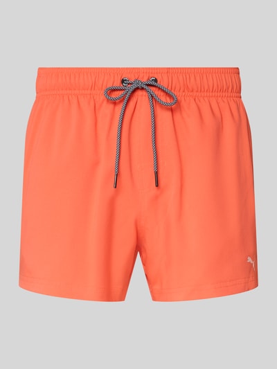 Produktfoto, Badehose mit Seitentaschen und Klettverschlusstasche hinten von PUMA in Orange, elastischer Bund, Regular Fit, glatte Textur.