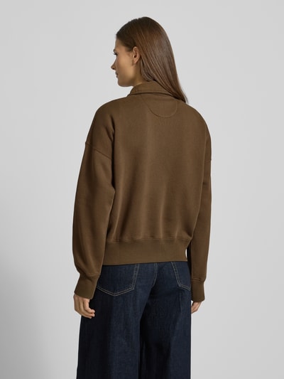 Kobiece model prezentuje bluzę Sweatshirt mit Label-Stitching od Polo Ralph Lauren, mieszanka bawełny, luźny krój, kołnierzyk polo, krótki zamek błyskawiczny, wyhaftowane logo, prążkowane wykończenia, ciemny brąz, prosty fason, gładka tekstura, całkowity widok z tyłu.