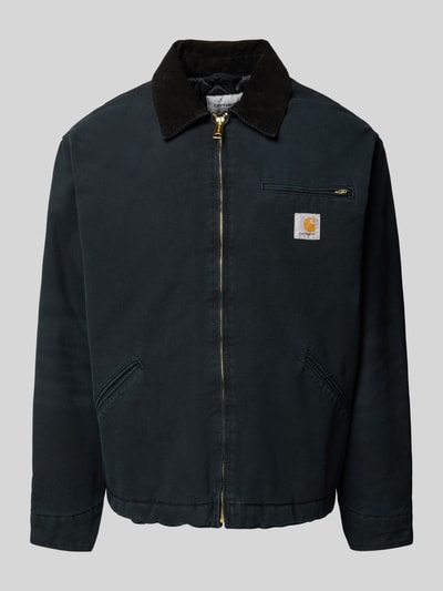 Produktfoto, schwarze Jacke mit Cord-Kentkragen, goldfarbenem Reißverschluss und Brusttasche, Jacke mit Brusttasche Modell 'DETROIT' von Carhartt Work In Progress, Regular Fit, sichtbarer Label-Patch, glatte Textur, klar strukturierte Formen, Vorderansicht.