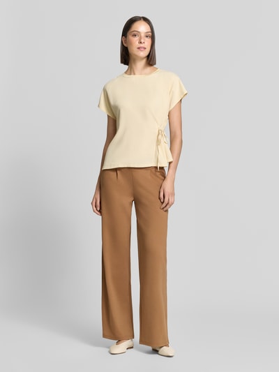 Frauenmodel trägt Wide Fit Hose mit Viskose-Anteil Modell 'Kate' von ICHI in Braun, Bundfalten, Eingrifftaschen, Ganzkörperansicht von vorne.