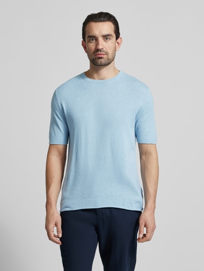 Männermodel trägt Strickshirt mit Kaschmir-Anteil und Knopfleiste von FTC Cashmere, hellblau, Baumwoll-Mix, Slim Fit, Polokragen, Ganzkörperansicht von vorne.