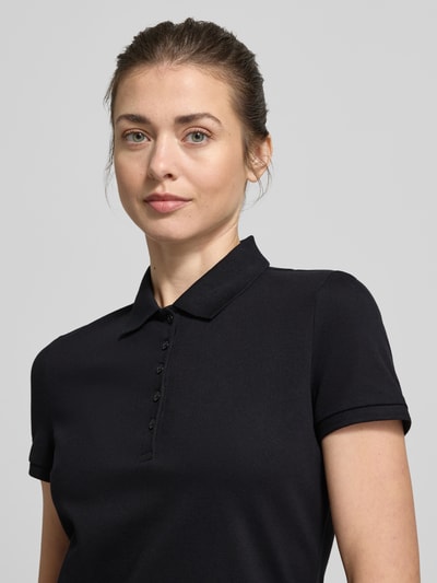 Frauenmodel trägt Slim Fit Poloshirt mit Knopfleiste von Christian Berg Woman aus Baumwoll-Elasthan-Mix, Nahaufnahme Oberkörper.