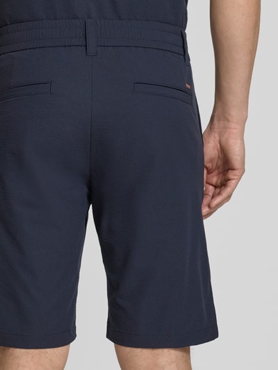 Męski model nosi Tapered Fit Bermuda mit Kordelzug Modell 'CHINO' od BOSS Orange, granatowy, crinkle, z nadrukiem, widok z tyłu z bliska