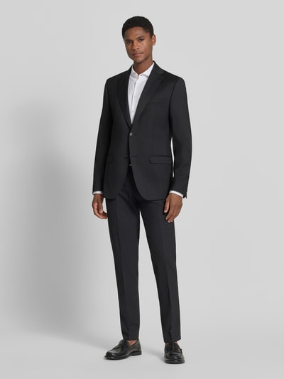 Männermodel trägt Anzughose mit Bügelfalten Modell 'Apollo' von DIGEL, schwarz, Material-Mix mit Schurwoll-Anteil, Slim-Fit, Ganzkörperansicht von vorne.