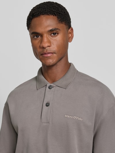 Männermodel trägt Relaxed Fit Poloshirt aus reiner Baumwolle von Marc O'Polo in Grau, strukturierte Oberfläche, Nahaufnahme Oberkörper. Herren Poloshirt von Marc O'Polo