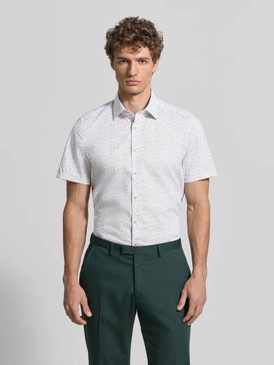 Männermodel trägt Slim Fit Business-Hemd mit Kentkragen von OLYMP Level Five, weiß mit Muster, Knopfleiste, Baumwoll-Mix mit Stretch-Anteil, Ganzkörperansicht von vorne.