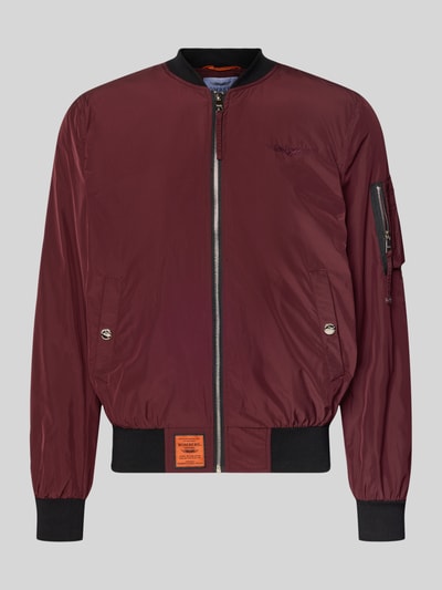 Produktfoto, 'Bomberjacke mit Label-Patch und Eingrifftaschen' von Original Bombers, bordowy kolor, proste linie, gładka tekstura, zapięcie na zamek, kieszenie z napą, rękaw z kieszenią na zamek, kontrastowe ściągacze, długość tyłu w rozmiarze M 67 cm, szerokość ramion w rozmiarze M 43 cm, szerokość w rozmiarze M 53 cm, długość rękawa w rozmiarze M 68 cm