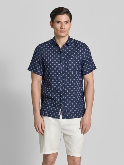 Männermodel trägt Regular Fit Leinenhemd mit Brusttasche von Scotch & Soda, dunkelblau mit Allover-Motiv-Print, Ganzkörperansicht von vorne. Reine Leinen, Regular-Fit, Brusttasche, Kentkragen, Kurzärmelig, durchgehende Knopfleiste, Logo-Patch, Rückenlänge bei Größe M: 75 cm, Schulterbreite bei Größe M: 42 cm, Ärmellänge bei Größe M: 24 cm.