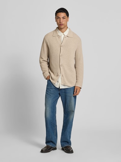 Männermodel trägt Cardigan aus Baumwoll-Mix von Closed in Beige mit Strukturmuster, durchgehende Knopfleiste, lockere Passform, Umlegekragen, Ganzkörperansicht von vorne.