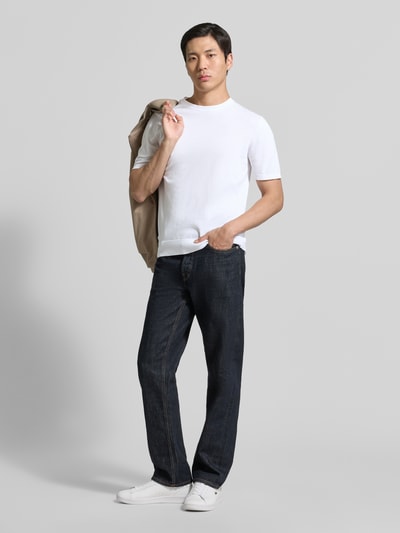 Männermodel trägt weißes Strickshirt mit Rundhalsausschnitt von MARKUP, Regular Fit, glatte Textur, Ganzkörperansicht von vorne.