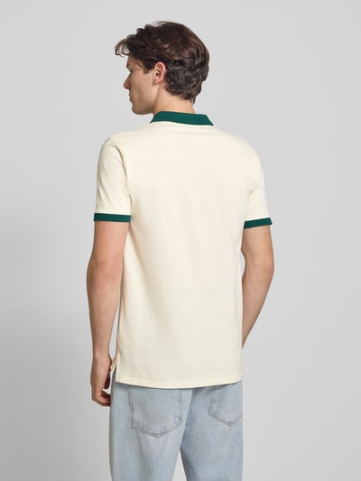 Männermodel trägt Regular Fit Poloshirt mit Label-Stitchings von ellesse aus Reine Baumwolle, cremefarben mit grünen Details, Ganzkörperansicht Rückansicht. Rückenlänge bei Größe M: 77 cm.
