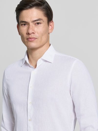 Männermodel trägt Slim Fit Freizeithemd aus Baumwoll-Leinen-Mix Modell 'Steven' von CINQUE in Weiß, Nahaufnahme Oberkörper. Rückenlänge bei Größe M 68 cm, Schulterbreite 42 cm, Ärmellänge 65 cm, Kentkragen, Langärmeliges Design, durchgehende Knopfleiste.