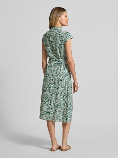 Frauenmodel trägt Midikleid aus Viskose-Mix mit Leinen-Anteil von Apricot, florales Muster in Grün-Weiß, tailliert, Rückansicht Ganzkörperansicht.