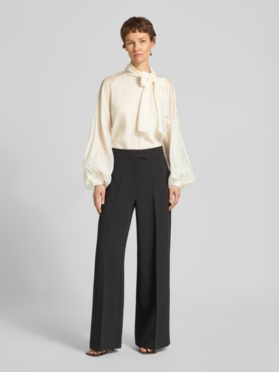 Frauenmodel trägt Blusenshirt aus Lyocell-Mix mit Schal von Copenhagen Muse in Creme, weite Ärmel, Relaxed Fit, Ganzkörperansicht von vorne.