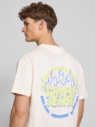 Männermodel trägt Relaxed Fit T-Shirt aus reiner Baumwolle von Tommy Jeans, Optik: Unifarben, Label-Print, Ganzkörperansicht Rückansicht.