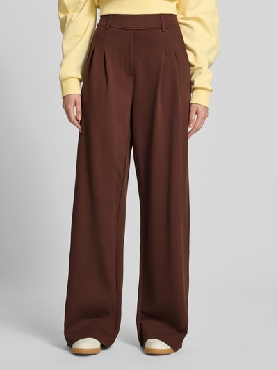 Frauenmodel trägt Wide Fit Stoffhose aus Viskose-Mix Modell 'Miri' von OH APRIL in Braun mit Bundfalten und Gesäßtaschen, Nahaufnahme Oberkörper