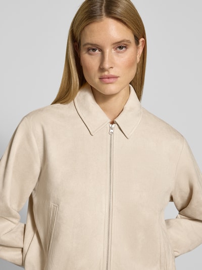 Kobiece modelka nosi Jacke in Leder-Optik mit Eingrifftaschen Modell 'DUVA' od FREE/QUENT, beż, krój regular fit, zbliżenie na górną część ciała