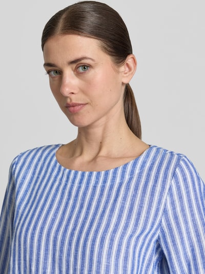 Vrouwenmodel draagt Regular Fit linnen blouse met 3/4-mouw van Christian Berg Woman, blauwe en witte strepen, ronde hals, detailopname bovenlichaam. Ruglengte maat 36: 64 cm, mouwlengte maat 36: 47 cm.