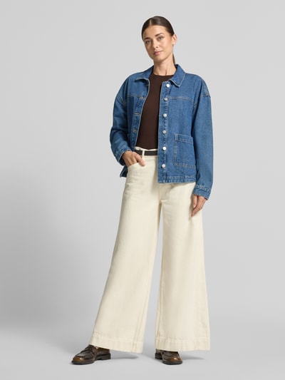 Frauenmodel trägt Regular Fit Pullover aus Viskose-Mix von s.Oliver RED LABEL in Braun, kombiniert mit Jeansjacke und weiten, hellen Stoffhosen, Ganzkörperansicht von vorne.