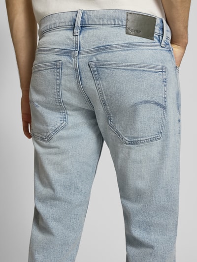 Männermodel trägt Slim Tapered Fit Jeans mit Eingrifftaschen Modell 'Streem' von G-Star Raw, hellblaue Baumwolle, Ganzkörperansicht Rückansicht.