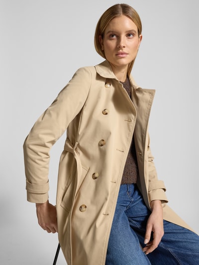 Frauenmodel trägt Trenchcoat mit Ärmelriegeln von Christian Berg Woman Selection in Beige, doppelreihig, tailliert, Nahaufnahme Oberkörper.