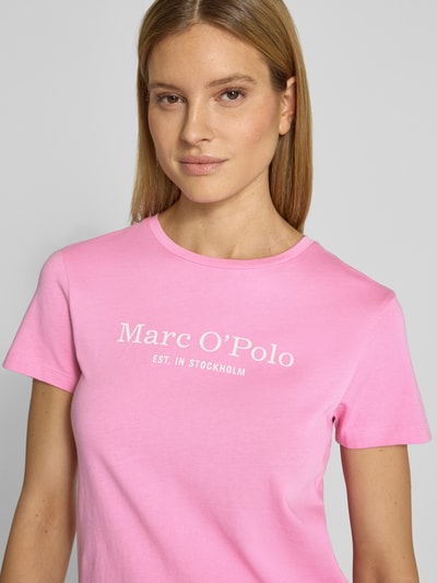 Vrouwenmodel draagt Regular Fit T-Shirt uit pure katoen van Marc O'Polo, effen roze kleur, label print, ronde hals, korte mouw, Nahaufnahme bovenlichaam.