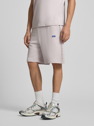 Männermodel trägt Regular Fit Sweatshorts aus reiner Baumwolle Modell 'NASENSIO' von HUGO, Optik: Unifarben, Label-Print, seitliche Eingrifftaschen, Bundabschluss elastisch, Materialverarbeitung: Sweat, Nahaufnahme Unterkörper, Ganzkörperansicht von vorne.