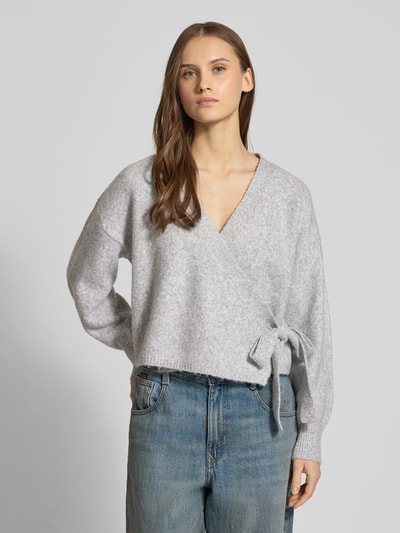 Frauenmodel trägt Regular Fit Cardigan mit Woll-Anteil Modell 'KIRA' von ONLY, Optik: Unifarben, Melange, Strickoptik, Wickeloptik, Verschluss: Taillengürtel, Kragenform: Crew Neck, V-Ausschnitt, Langarm, gerippte Abschlüsse, Material: Material-Mix mit Woll-Anteil, Farbton Grau, Grobstrick-Textur, Ganzkörperansicht von vorne.