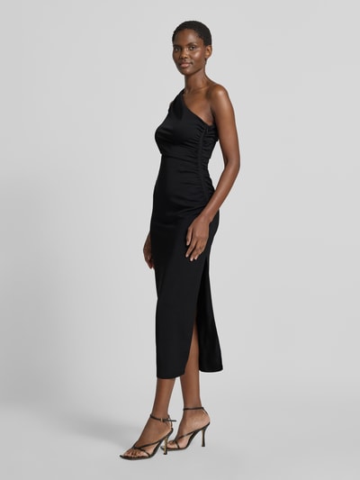 Frauenmodel trägt Eng anliegendes Cocktailkleid mit One-Shoulder von Jake*s Cocktail, schwarz, glatte Stoffstruktur, Ganzkörperansicht von vorne.