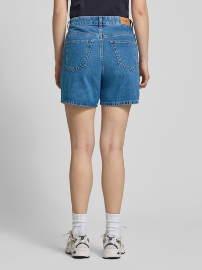 Frauenmodel trägt Bermuda Leg Jeansshorts aus reiner Baumwolle von Marc O'Polo Denim in klassischer Denim-Optik, 5-Pocket, Label Patch, Ganzkörperansicht Rückansicht.