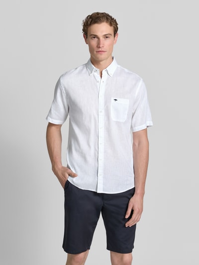 Männermodel trägt Slim Fit Freizeithemd aus Leinen-Baumwoll-Mix von Fynch-Hatton in Weiß mit Button-Down-Kragen, Brusttasche, Label-Stitching, Knopfleiste, Rückenlänge 74 cm, Schulterbreite 48 cm, Ärmellänge 26 cm, Ganzkörperansicht von vorne.