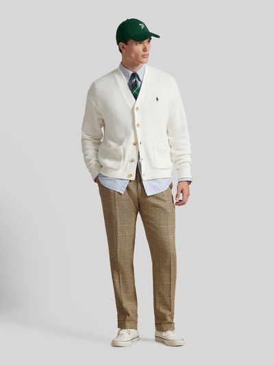 Männermodel trägt Regular Fit Strickjacke aus reiner Baumwolle von Polo Ralph Lauren in Weiß mit Knopfleiste und Logo, Ganzkörperansicht von vorne.