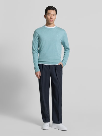 Männermodel trägt Regular Fit Strickpullover aus reiner Baumwolle von Tom Tailor in Hellblau, unifarben, Melange, Ganzkörperansicht von vorne.