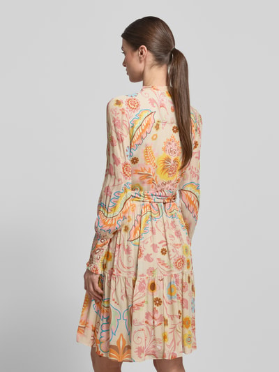 Frauenmodel trägt Regular Fit Kleid mit floralem Allover-Print von HERZENS in zarten Pastellfarben, Stehkragen, langärmelig, tailliert, abnehmbares Stoffband, elastische Ärmelabschlüsse, Knopfleiste, florales Allover-Muster, Rückenlänge 97 cm, Brustweite 52 cm, Ärmellänge 65 cm, Ganzkörperansicht Rückansicht.