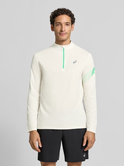Męski model nosi bluzkę z długim rękawem z kołnierzem zapinanym, nadruk z logo, Model 'ICON' od ASICS TIGER, prosty krój, Długość tyłu w rozmiarze M: 72 cm, jasnokremowy kolor, przód z całego ciała.