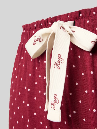 Produktfoto, bordeauxrote Loose Fit Pyjama-Hose aus Modal-Baumwoll-Mix von HUGO mit weißen Punkten und cremefarbenem Band, Damen Pyjama von HUGO