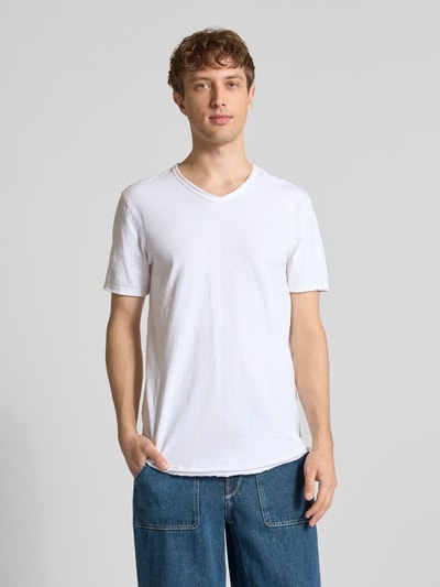 Męski model nosi Regular Fit T-Shirt aus reiner Baumwolle Modell 'BENNE LONGY' von Only & Sons, biała, gładka, krój regular fit, V-neck, krótki rękaw z wywinięciem, bawełna, widok całej sylwetki z przodu.