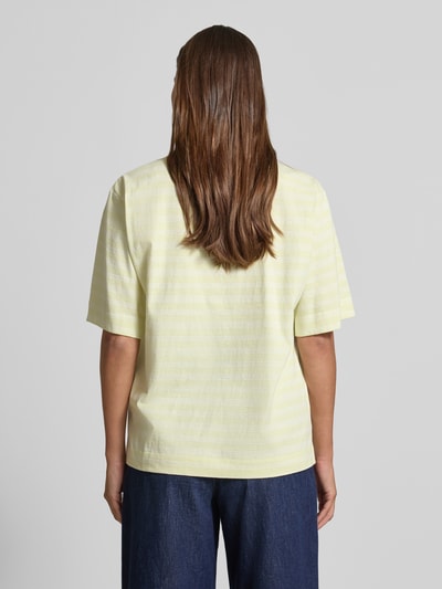 Frauenmodel trägt Oversized Damen T-Shirt aus reiner Baumwolle Modell 'C_EREGULAR_STRIPE' von BOSS Orange, Optik:Allover-Muster, Streifen-Muster, Passform: Oversized, mit Label-Stitching-Applikation, Rundhals-Ausschnitt, Ärmelform: Kurzarm, Materialverarbeitung: Jersey, Allover-Streifenmuster in Gelb und Weiß, Textur weich, Ganzkörperansicht Rückansicht.