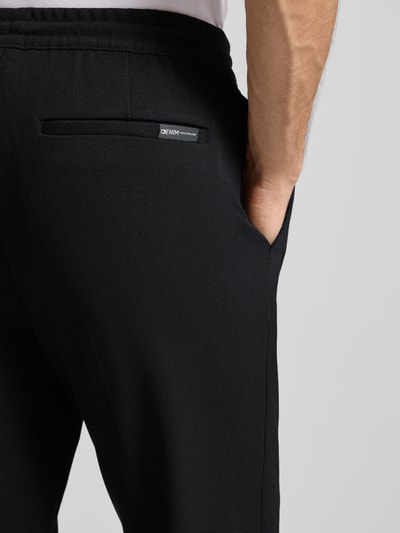 Männermodel trägt Tapered Chino mit Viskose-Anteil von Tom Tailor Denim, Optik: Unifarben, seitliche Eingrifftaschen, Nahaufnahme Hüfte.