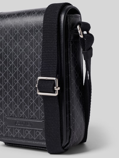Produktfoto, schwarze Handytasche mit Allover-Muster Modell 'EMBLEM AOP' von CK Calvin Klein für Herren, strukturierte Oberfläche