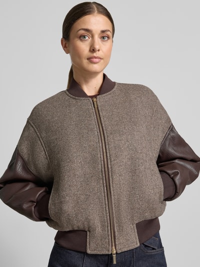 Frauenmodel trägt Blouson in Leder-Optik von Armani Exchange, braune Töne, lockere Passform, elastischer Material-Mix, Nahaufnahme Oberkörper.