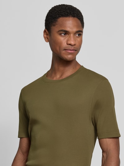 Männermodel trägt Slim Fit T-Shirt mit Rundhalsausschnitt Modell 'ENIL' von Drykorn aus Reine Baumwolle in Oliv, Feinripp, Nahaufnahme Oberkörper.