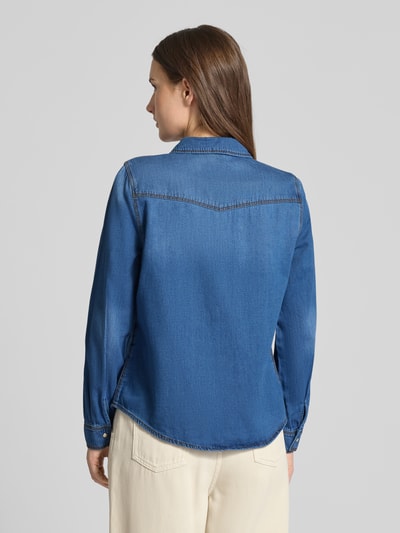 Frauenmodel trägt Regular Fit Jeanshemd aus reiner Baumwolle Modell 'MARIA' von Vero Moda in klassischem Denim-Blau, Ganzkörperansicht Rückansicht.