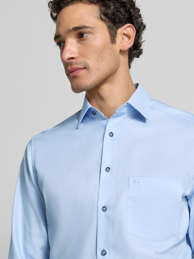 Männermodel trägt hellblaues Modern Fit Businesshemd aus reiner Baumwolle von OLYMP, feine Textur, Nahaufnahme Oberkörper, Herren Businesshemd von OLYMP.