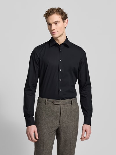 Męskimodel nosi Regular Fit Businesshemd mit extra langem Arm od OLYMP Level Five, jednokolorowy, mieszanka bawełny, kołnierzyk typu kent, długa listwa guzikowa, sportowe mankiety, materiał o gładkiej teksturze, pełny widok z przodu.