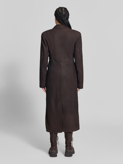 Frauenmodel trägt Ledermantel aus echtem Leder von ROTATE in Dunkelbraun, strukturierte Velours-Oberfläche, tailliert, Ganzkörperansicht Rückansicht. Rückenlänge 129 cm, Brustweite 42 cm, Ärmellänge 66 cm, Doppelreiher mit Reverskragen und Klappentaschen.