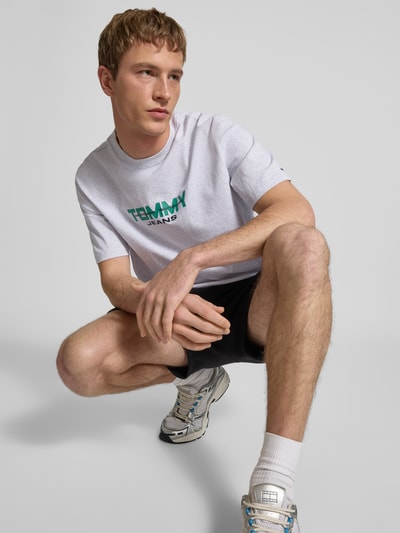 Männermodel trägt Regular Fit T-Shirt aus reiner Baumwolle von Tommy Jeans in Optik: Unifarben, Label-Schriftzug, Nahaufnahme Oberkörper.