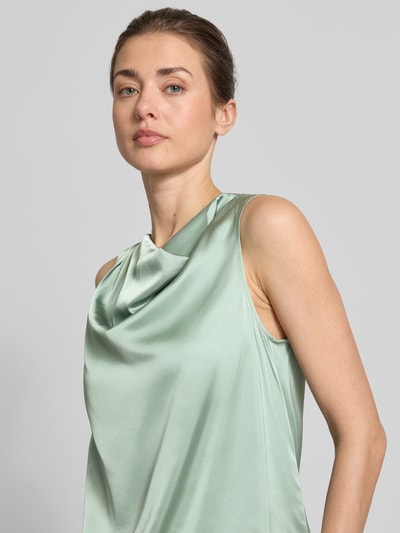 Frauenmodel trägt Blusentop mit Wasserfall-Ausschnitt von Comma, Material-Mix mit Viskose-Anteil, Regular-Fit, zart glänzend, Drapierungen, Nahaufnahme Oberkörper.